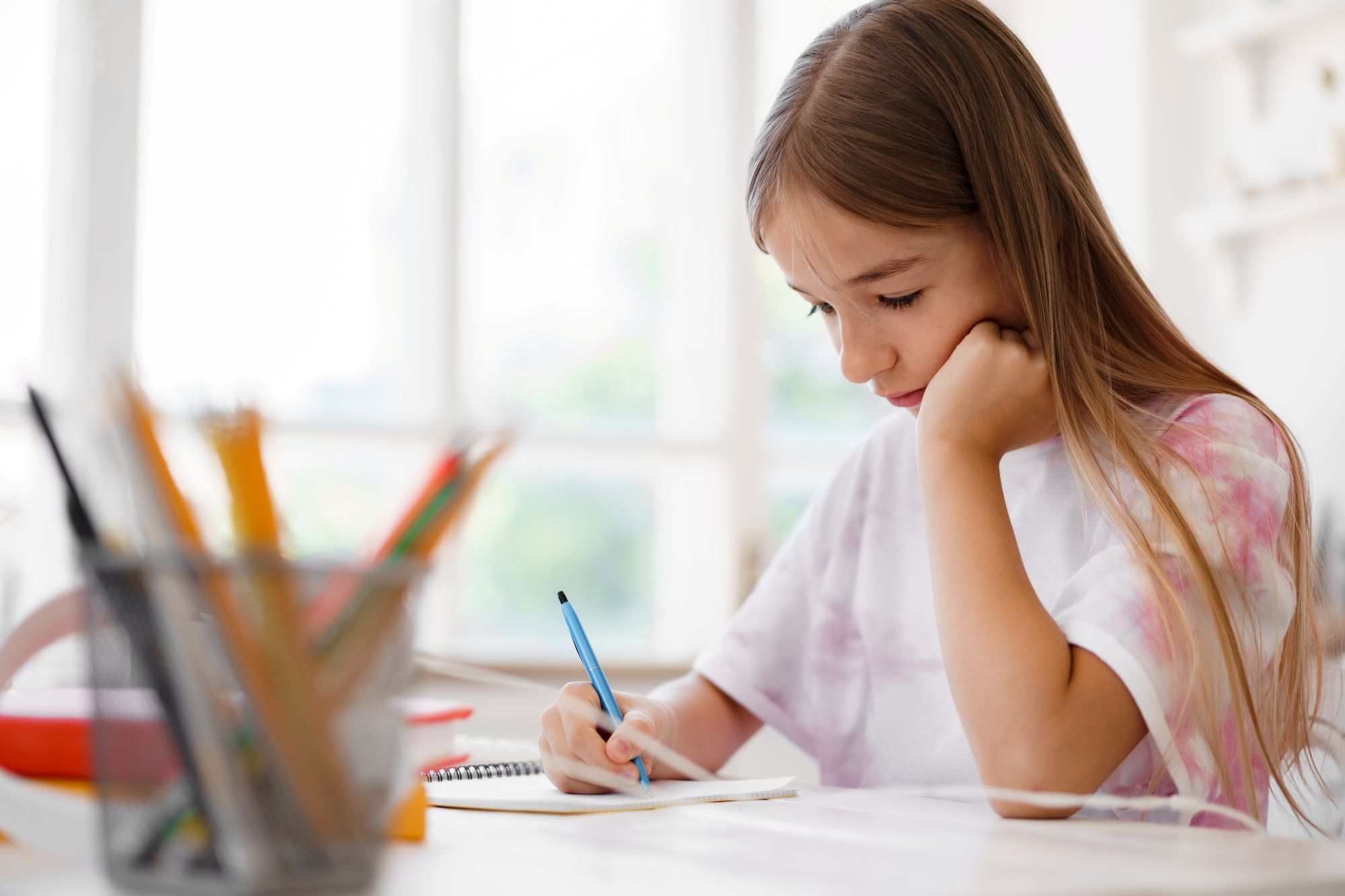 teenage girl making notes in notepad doing
